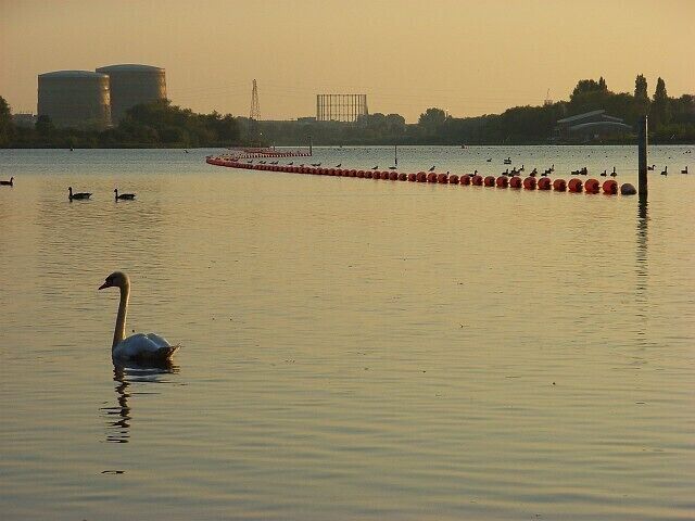 Former gravel pit, Sonning. The gravel pits occupy a large swath of the flood plain between Sonning Eye and Caversham. They are now used for watersports and fishing and attract a lot of wildfowl. The building to the right is a new rowing centre. The gasworks is in the east end of Reading, a couple of miles away. For the same view in winter see 657828.