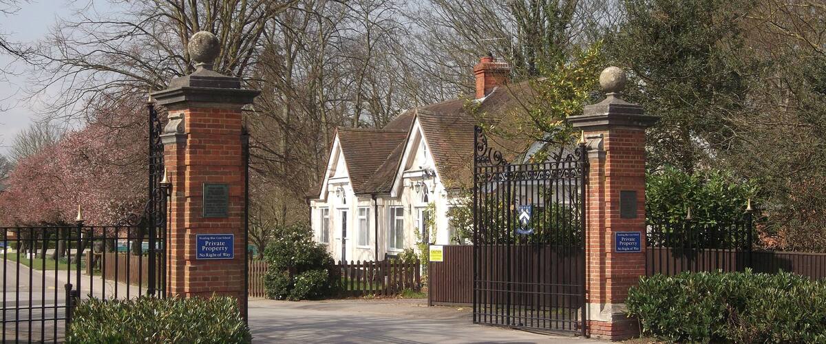 A gated entrance to a private property with a brick wall and metal gates.