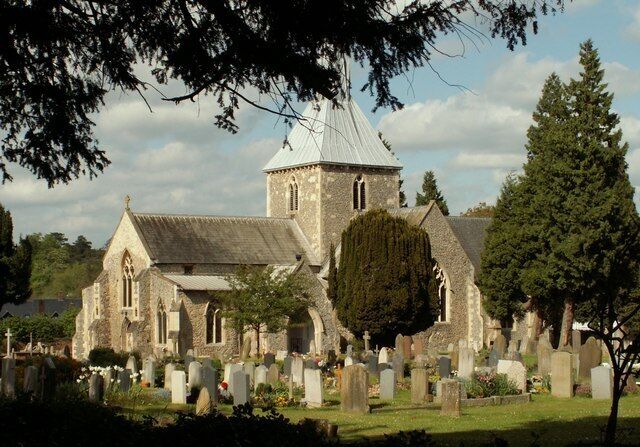 A church with a tower and a cemetery in the foreground.