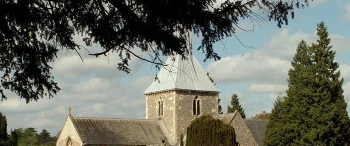 A church with a tower and a cemetery in the foreground.