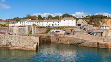 A coastal town with stone buildings, a harbor, and a cliff.