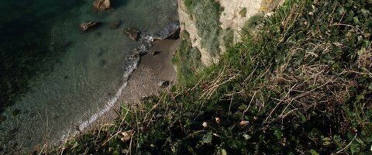 Cliff above Fanny's Beach The cliff is around 40 metres high here. Much of the beach is covered by the high tide. Gull Island, the large stack about 230 metres away, is in SX0451.