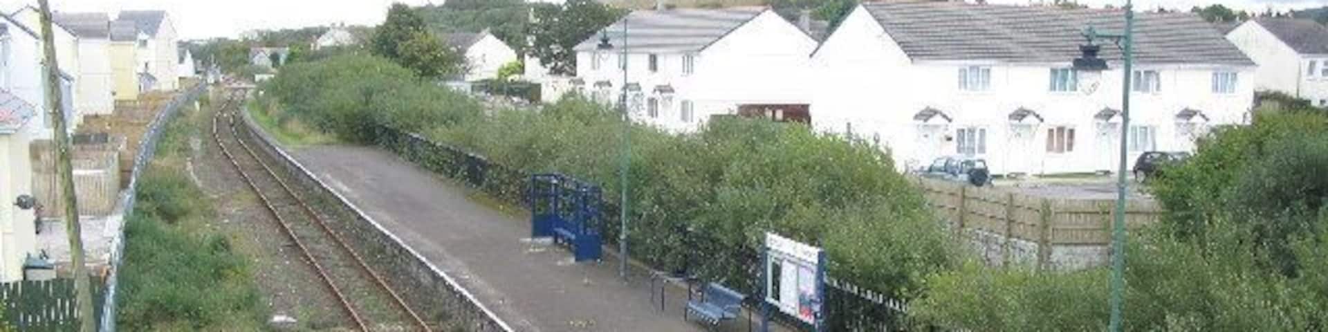 Bugle Station. This station on the Newquay branch line used to be an island platform. The second line ran in the now overgrown area between the platform and the white buildings at right. The station now only has pedestrian access, the station yard having been used for housing.