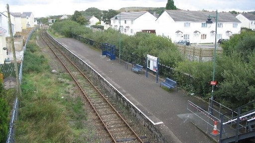 Bugle Station. This station on the Newquay branch line used to be an island platform. The second line ran in the now overgrown area between the platform and the white buildings at right. The station now only has pedestrian access, the station yard having been used for housing.