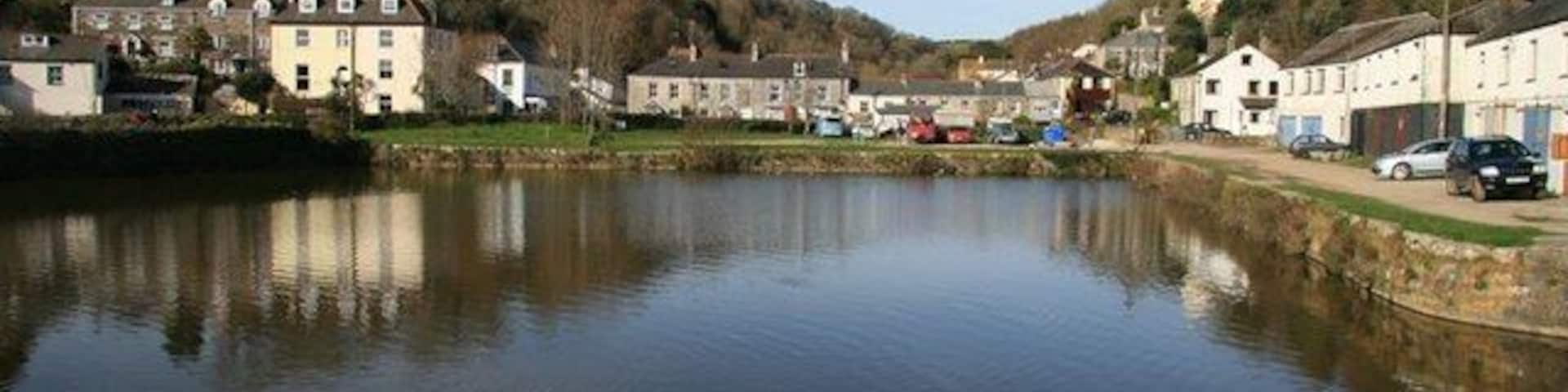 Pentewan harbour. A view across Pentewan harbour, which was connected to St Austell by the Pentewan railway. China clay and tin were exported from here and coal was imported. The harbour fell into disuse when the entrance passage silted up in 1916.