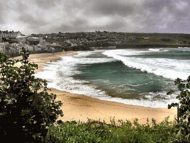 Uma cidade costeira com uma praia arenosa e ondas quebrando na costa.