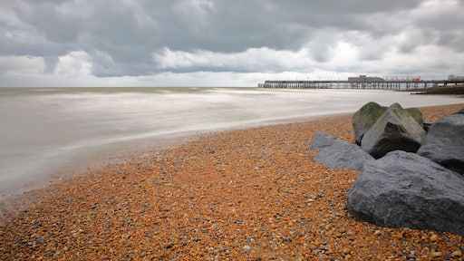 The colorful beach of Hastings with the Pier (rebuilt in 2016) in the background and a cloudy sky, Hastings, UK