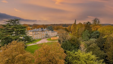 Bowcliffe Hall Yorkshire stately home, wedding venue and offices close to the A1, York, Leeds and Bramham Park. Drone photo showing the front of the main building and trees on an autumn day at sunset