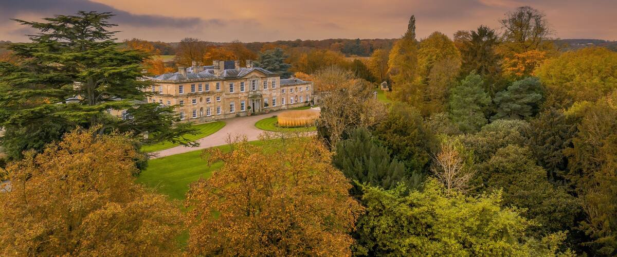 A large stately building surrounded by autumn foliage.