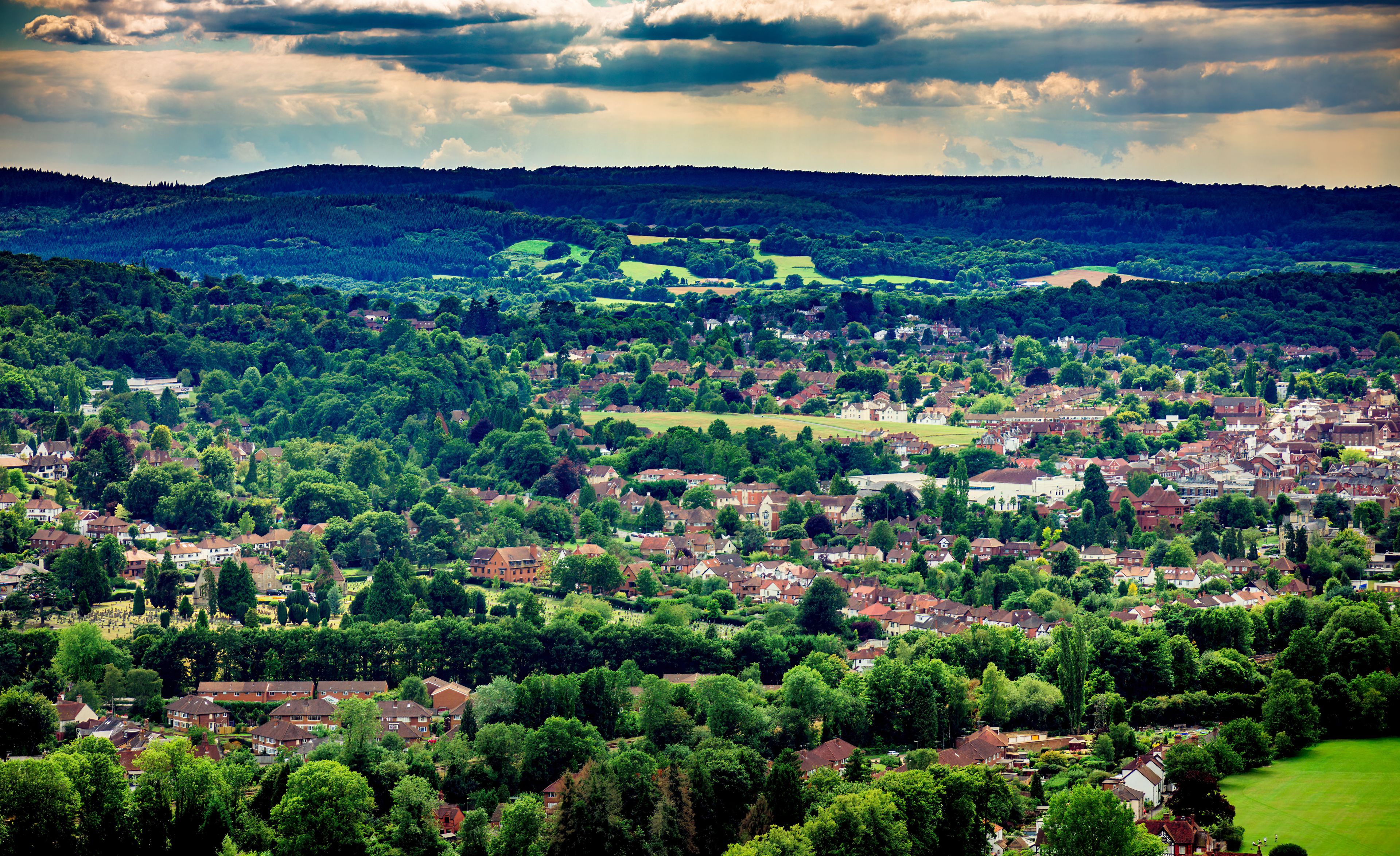 A town nestled in a valley with rolling hills in the background.