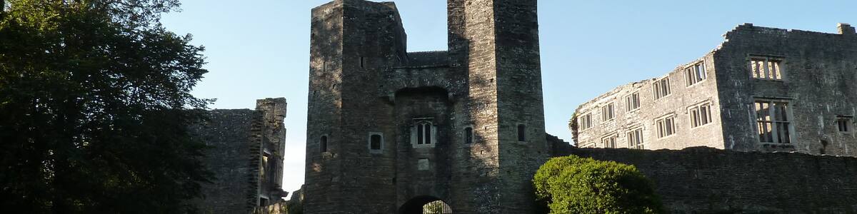 Eine historische Burg mit einem zentralen Turm, einem Tor und umlaufenden Mauern.