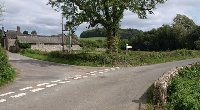 Junction, Littlehempston. The lane on the left leads past Higher Court Farm towards Uphempston. A few metres along to the right is 942519, and the Gatcombe Brook runs just beside the wall on the right.