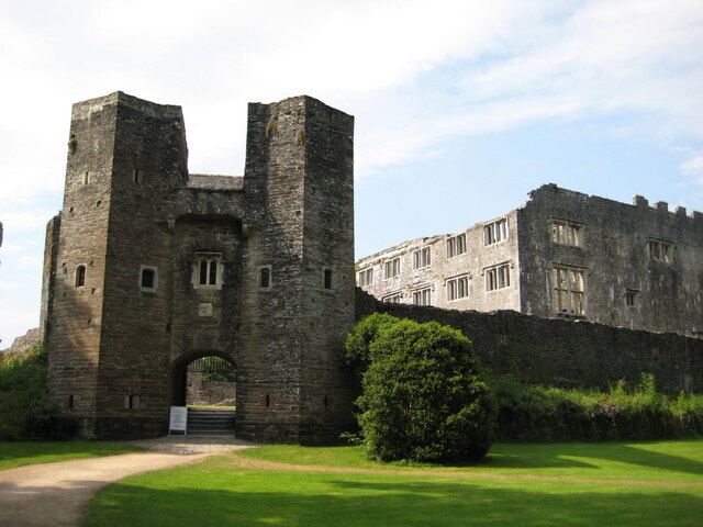 Un castillo de piedra histórica con dos torres destacadas y una gran entrada en arco.