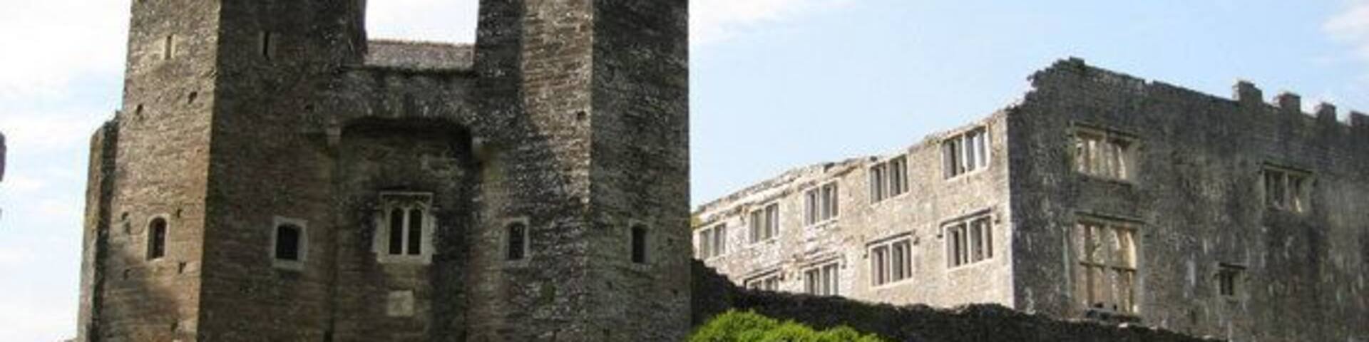 A historic stone castle with two prominent towers and a large arched entrance.
