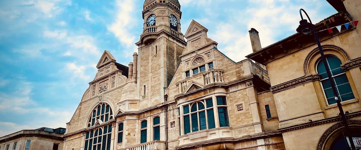 A historic building with a prominent clock tower and arched windows.