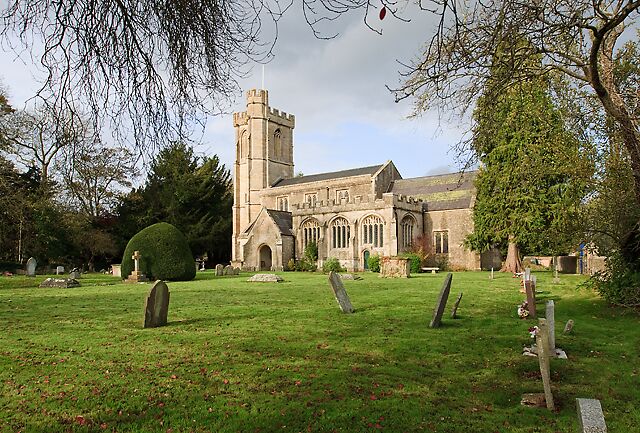 A church with a tower and a graveyard with headstones.