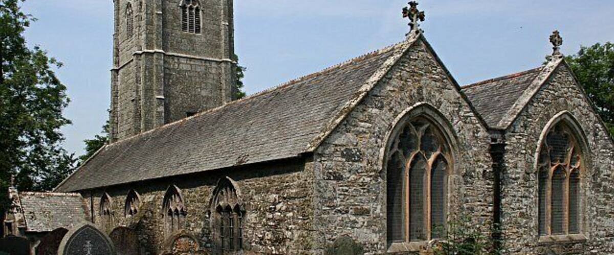 A historic stone church with a tall bell tower and arched windows.