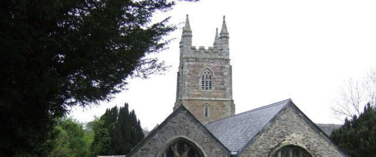 A stone church with a tall tower and arched windows.
