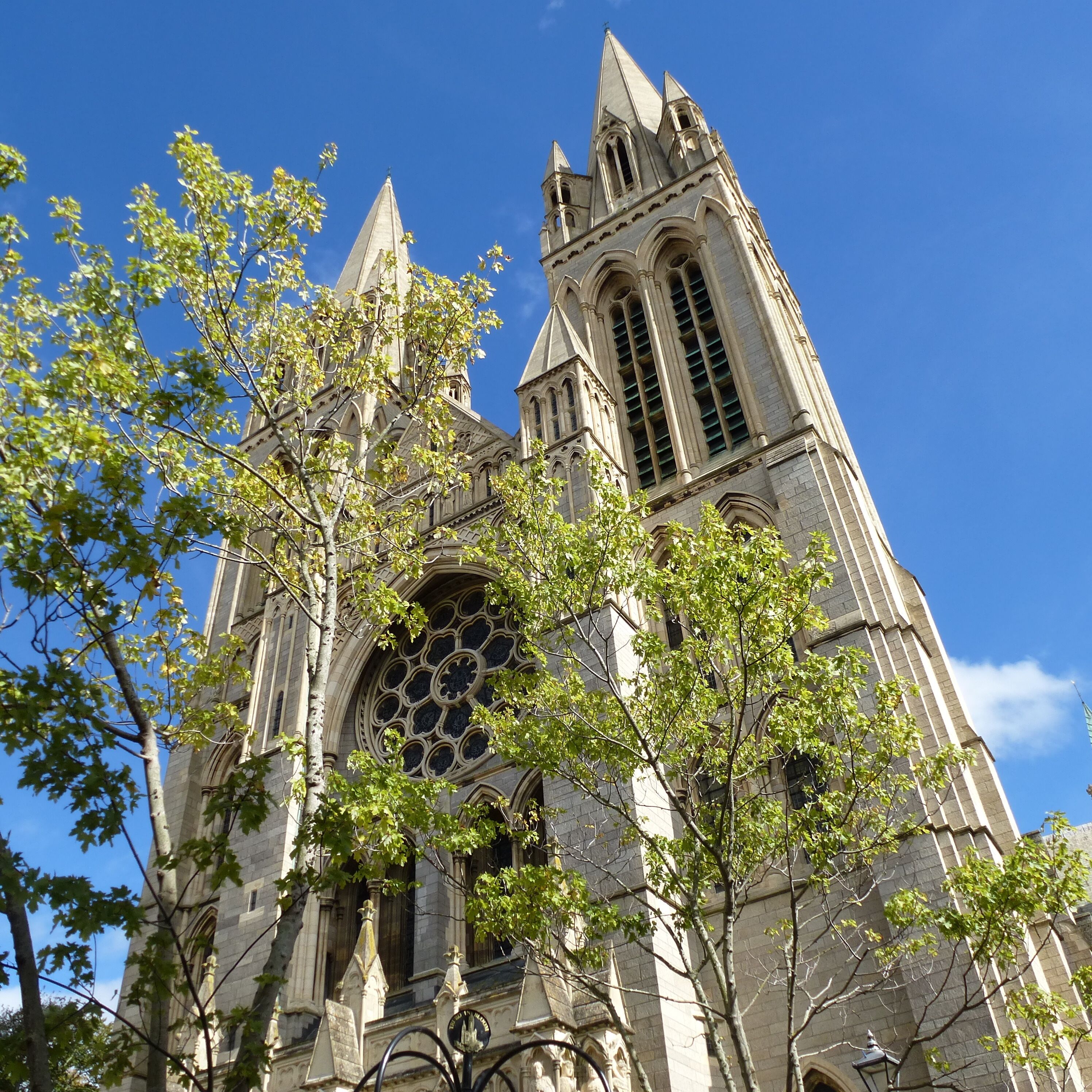 A Gothic-style church with a tall spire, large rose window, and stone facade.
