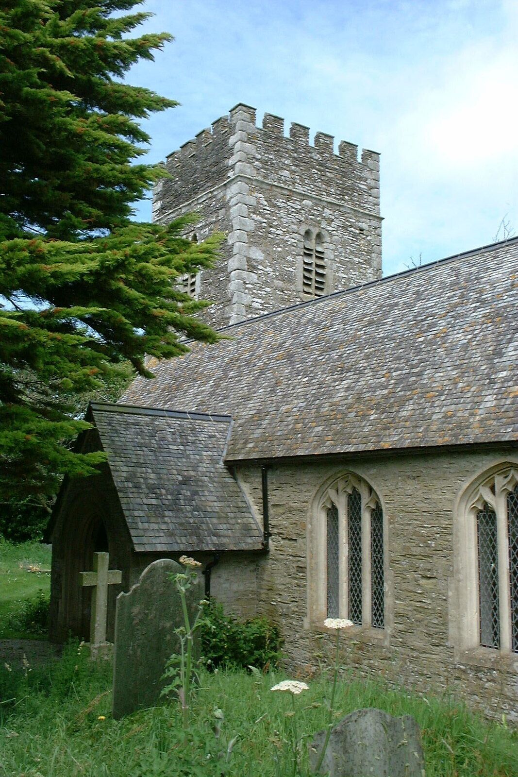 A stone church with a tower and arched windows.