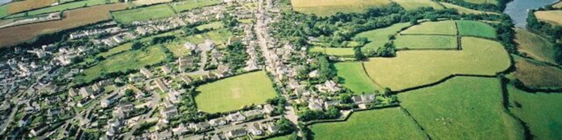 Aerial view from Paramotor of Roseland Peninsula - Portscatho in foreground, St Anthony's Head and Fal Estuary in distance