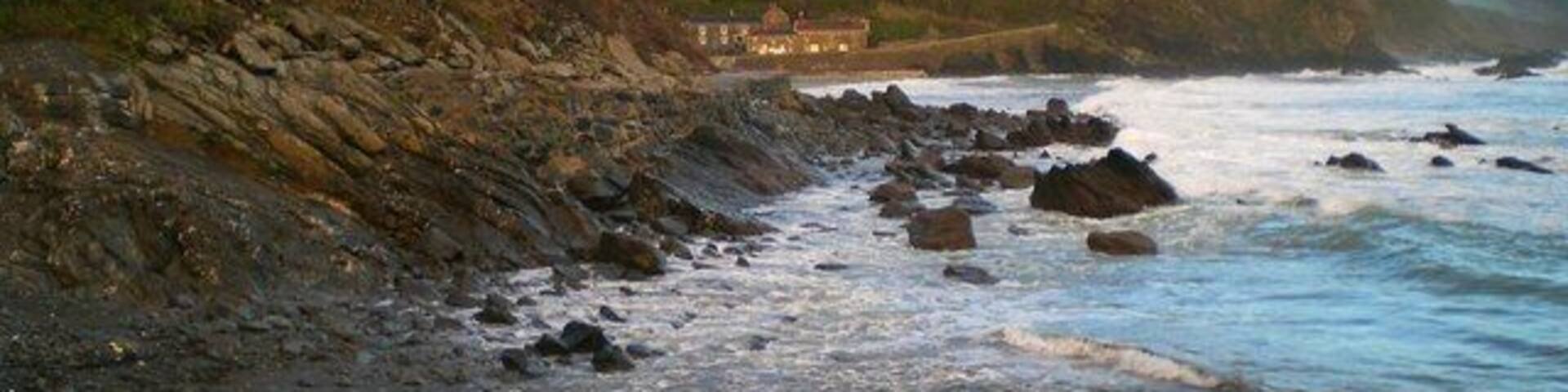 Portholland from West Portholland Portholland is a lovely secluded village by the sea. The beaches of East and West Portholland become one at low tide. The tide is in here, but going out.
