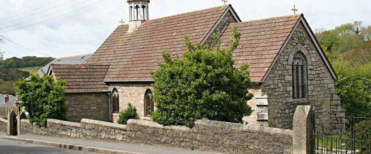 A stone church with a tiled roof and a bell tower.
