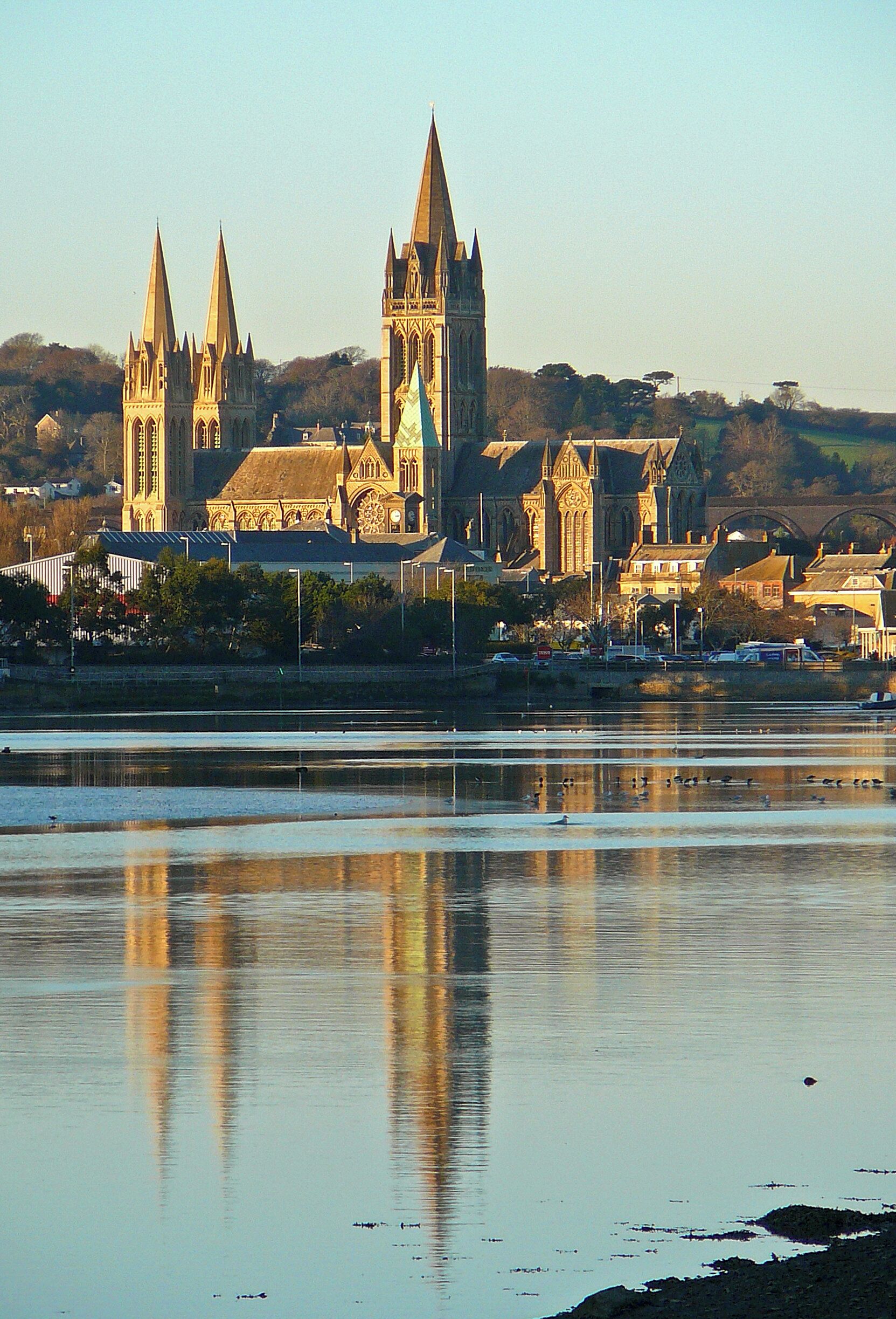 Una catedral con altas agujas y un río al frente.