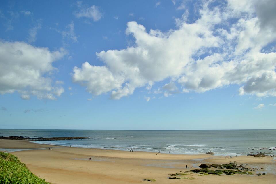 A beach with a clear sky and waves.