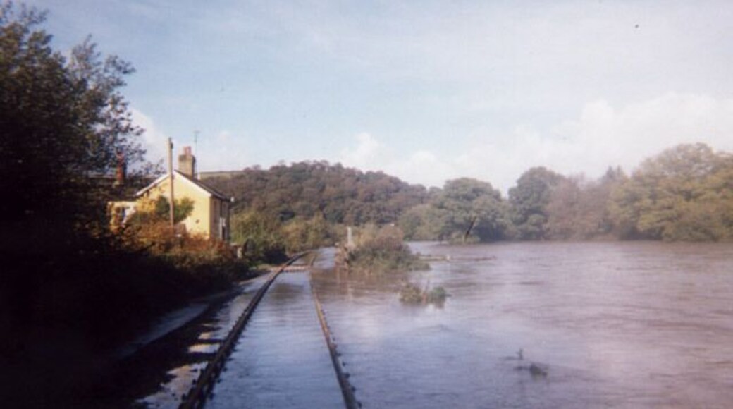 Higher Doomsford Crossing / River Taw. This photo is taken on the Exeter to Barnstaple railway branch line, looking North. The railway, completed in 1854, runs next to the River Taw for this stretch. This was taken in the flood of October 2000. The railway acts as a levee protecting the crossing keeper's cottage.