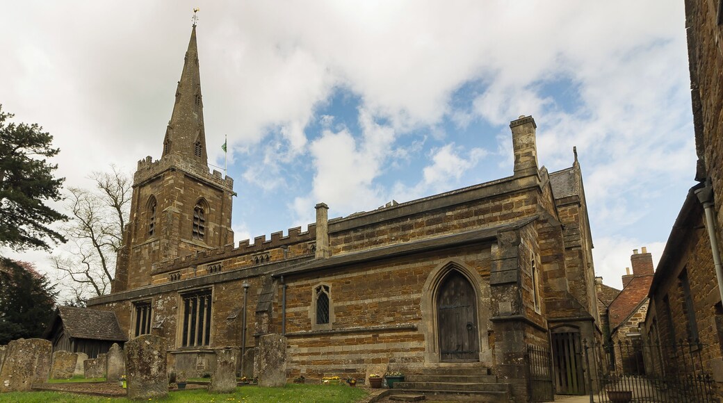 No church is mentioned in the Domesday book, although it may be identified with one of three churches attached to the Manor of Ridlington, north of Ayston. It was granted to the Abbey of Westminster in the eleventh century. The church itself dates from the fourteenth century onwards and consists of a western tower, nave with north and south aisles and clerestory, chancel and north chapel, organ chamber and vestry, and north and south porches. The tower is of three stages with angle buttresses and has a tall recessed spire with three tiers of lucarnes. There are eight bells. The nave is of four bays (lengthened by one Bay in the 1861 restoration). The north aisle is from the Decorated period, the south aisle is Perpendicular. There are remnants of wall decoration on the south arcade consisting of red flowers and tendrils. The chancel was rebuilt in 1861 when it was restored by Parsons of London incorporating black marble columns to the north chapel (Lady Chapel) and organ chamber. During the reconstruction some sculptured fragments of the twelfth century were found, two of which are now built the wall on either side of the north door. A Coffin lid of the thirteenth century was also found. There is a plain mediaeval octagonal font at the west end of the nave and a two manual organ by Harrison and Harrison. The church is surrounded on the north side by the buildings of the marketplace. Pic by Jenny.