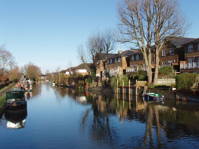 Canal with houses on Jacks Lane View from towpath bridge over the spillway from the canal to the River Colne. The houses have a frontage onto Jacks Lane, and gardens with moorings on the canal.