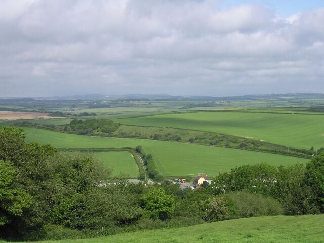 Farmland north of Bere Regis. Looking down on the grid square from Woodbury Hill hillfort. The cutting containing the A35 Bere Regis bypass can be seen across the centre of the photo.