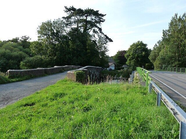 Old and new bridges at Holmebridge The bridges cross the River Frome. The old bridge dates from the 15th century and has been much altered with new brick parapets added after tank training damage during World War One. It is still possible to drive across this bridge, diverting from the B3070 on the right.