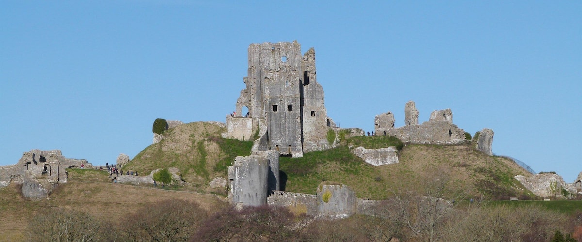 Corfe Castle is a fortification standing above the village of the same name in the English county of Dorset. Built by William the Conqueror, the castle dates back to the 11th century and commands a gap in the Purbeck Hills on the route between Wareham and Swanage.