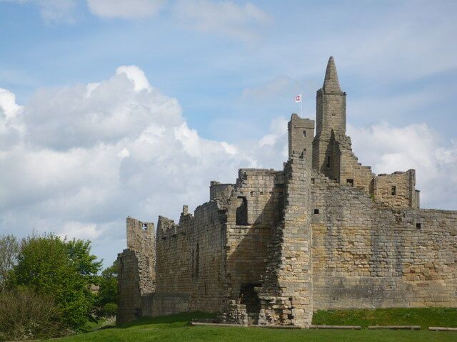A historic stone castle with multiple towers and a flag.