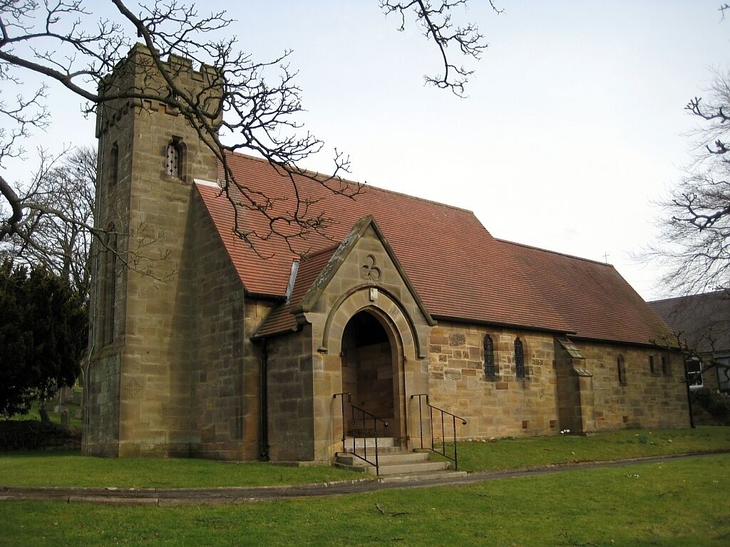 A stone church with a red-tiled roof and a bell tower.