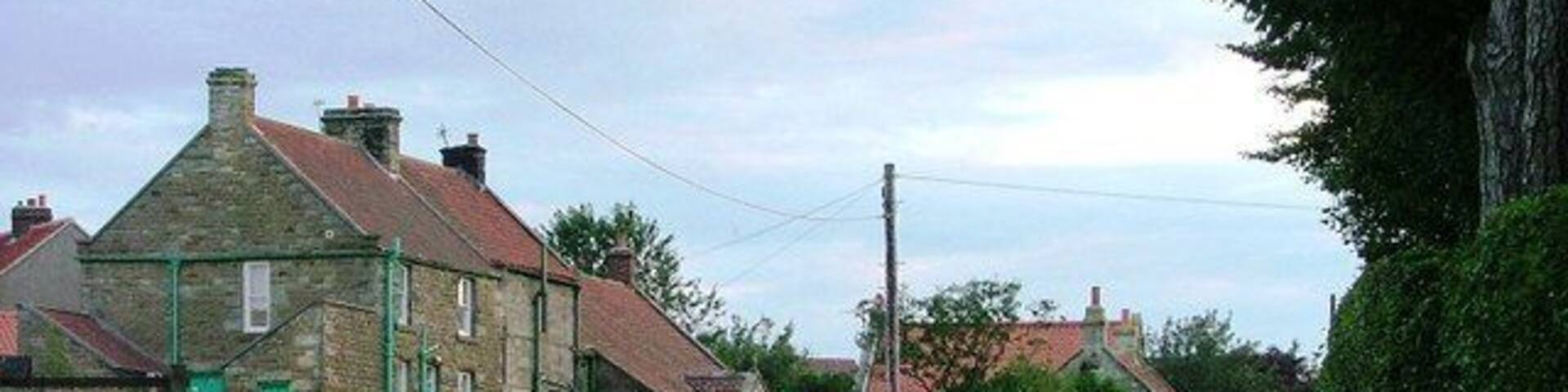 Ugthorpe. A late evening view looking west along the road towards the centre of the village taken from near Christ Church.