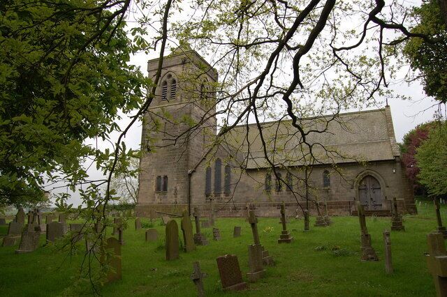 A church with a tower and multiple tombstones in the foreground.