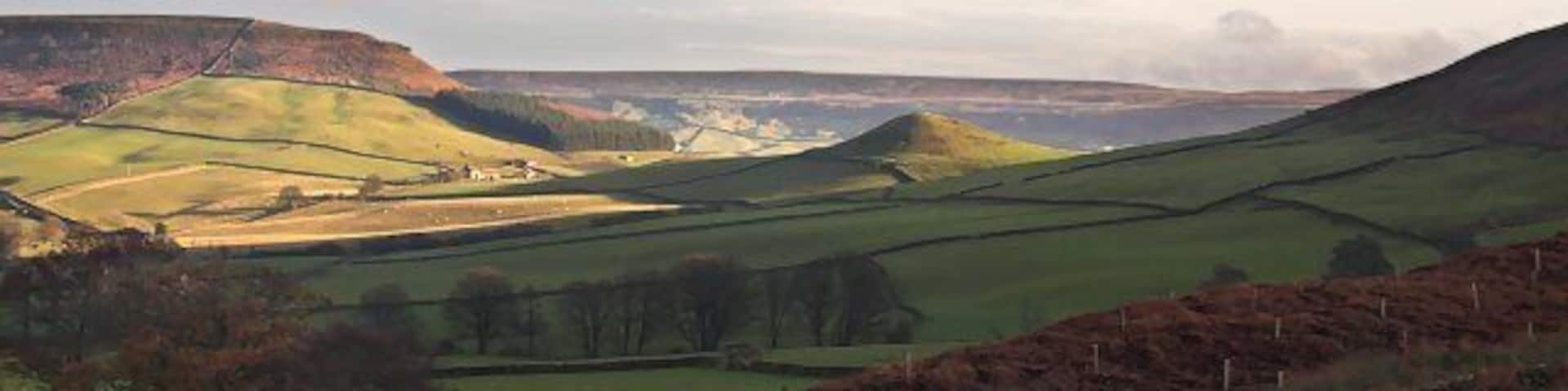 Rolling hills, a river, and a stone wall.