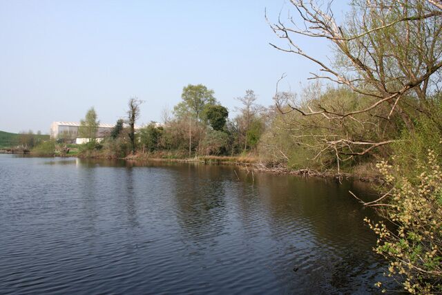 Mere at Fenn's Bank This large mere, one of two divided by a disused railway line, is adjacent to the Mereside industrial estate at Fenn's Bank; the factory buildings visible probably form part of the H. H. Wardle (Metals) Ltd aluminium works. Despite the adjacent factories, the mere is home to many wildfowl. View from a small promontory off the wooded east bank