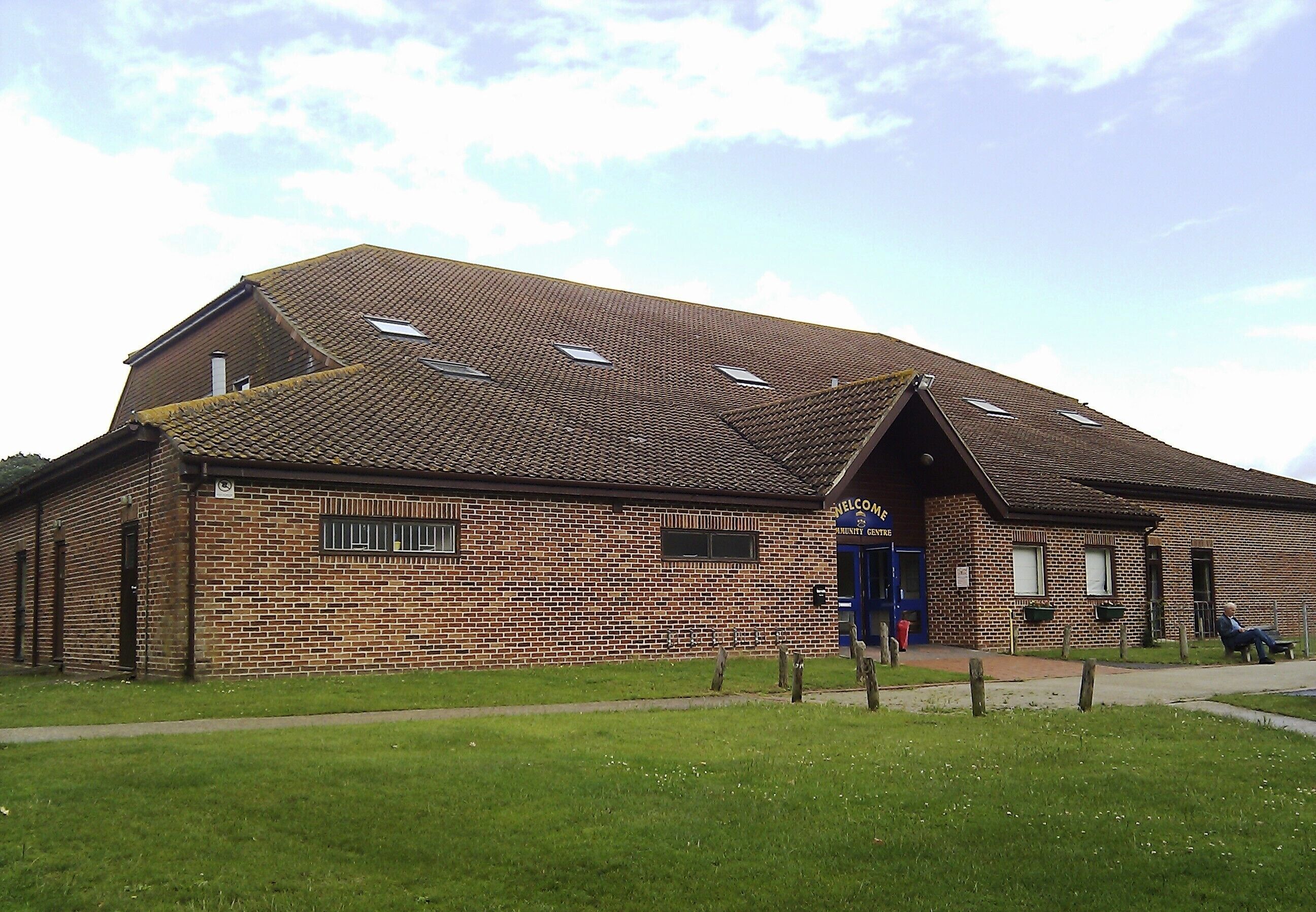 A brick building with a sloped roof and skylights.