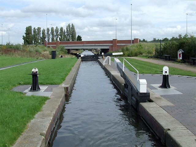 Curdworth Top Lock, Birmingham and Fazeley Canal, Warwickshire There are eleven locks, some widely spaced, in the flight at Curdworth. The total drop in water level over about three miles is 76ft 4in (23.3 metres). Ahead, the M6 toll motorway (opened in December 2003) crosses the canal. The canal was opened in 1789.