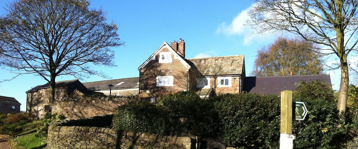 A stone wall, a stone building, and a signpost.