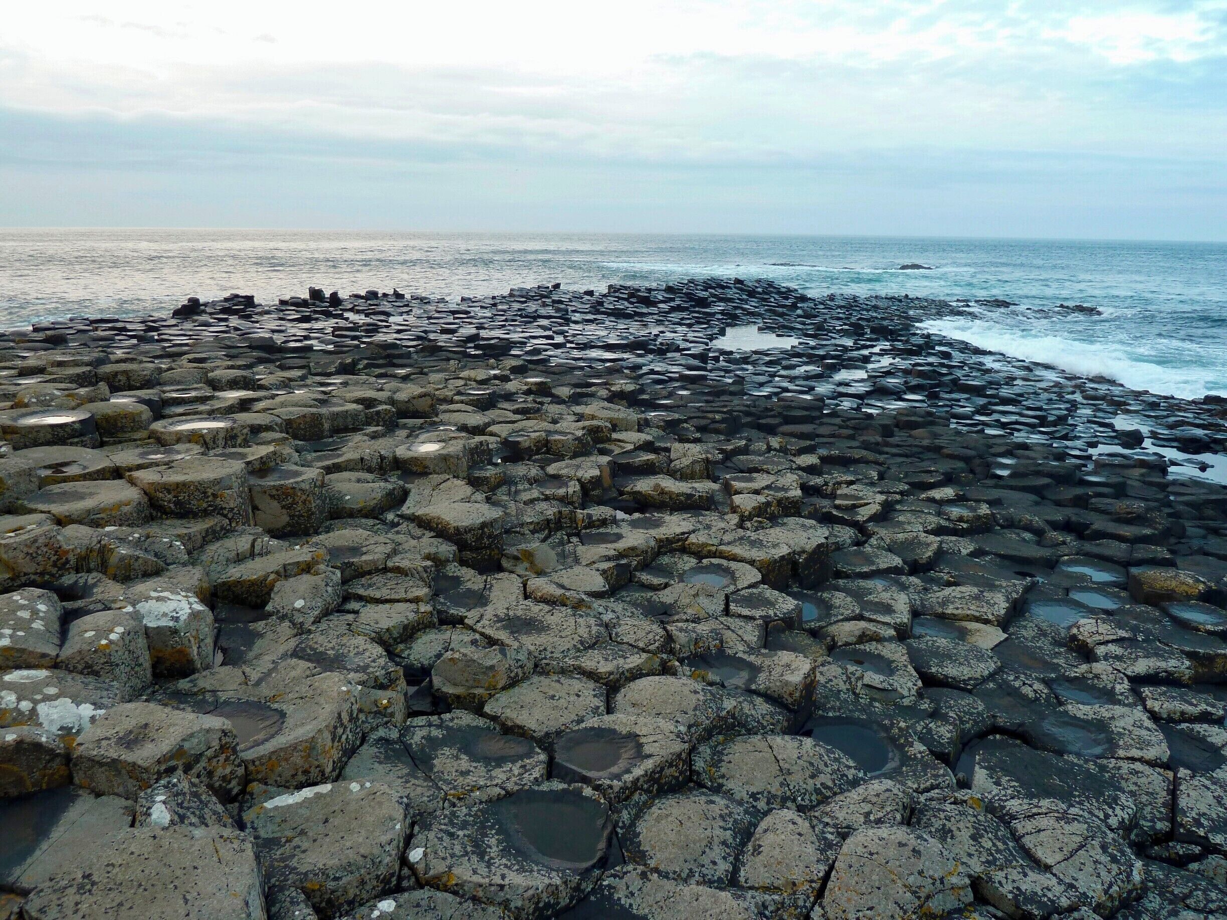 Una playa rocosa con formaciones basálticas hexagonales.