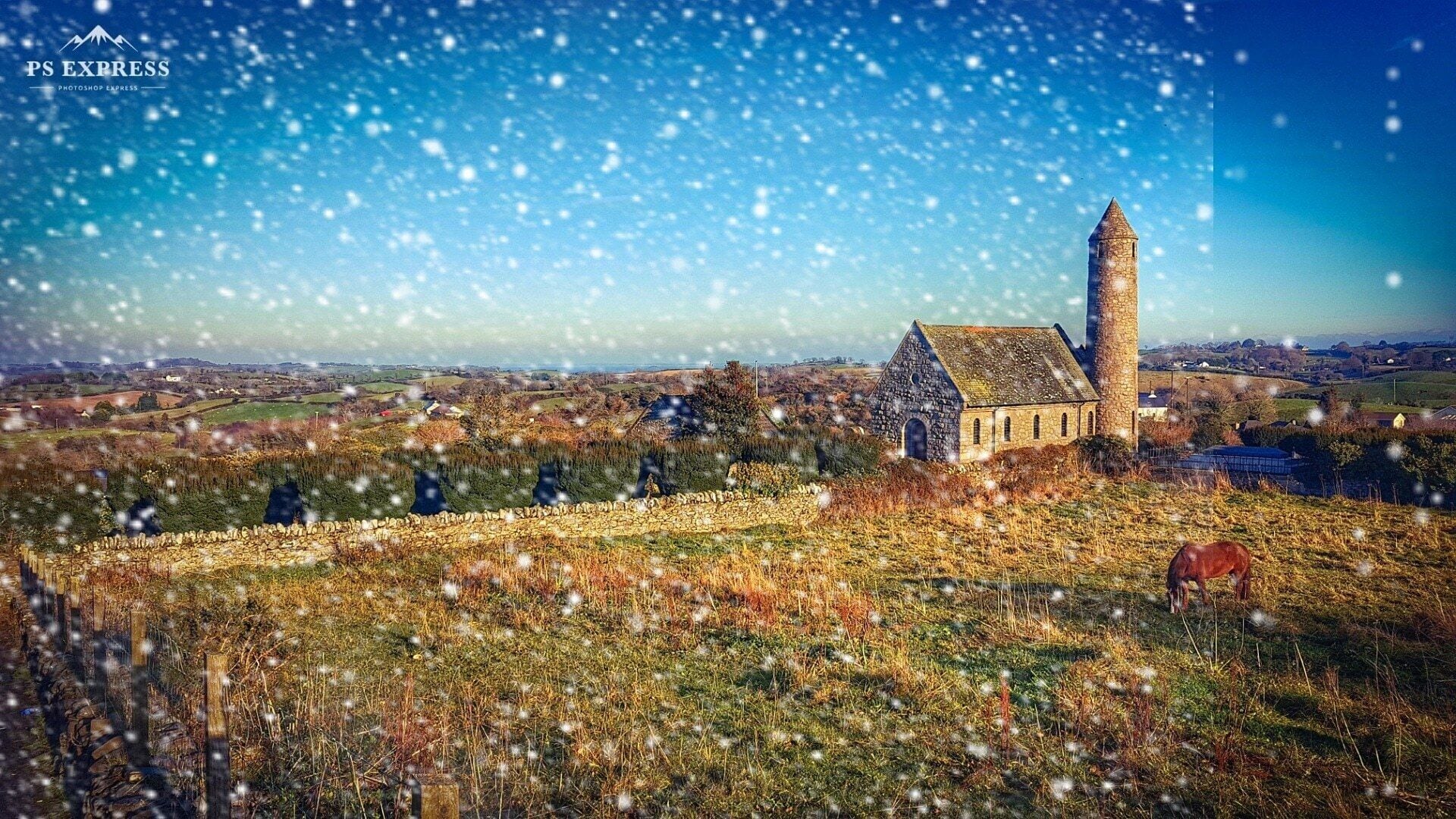 A stone church with a bell tower, surrounded by fields and a distant village.