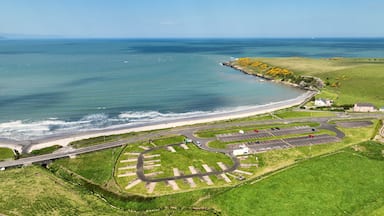 A coastal road with a parking lot and a beach.