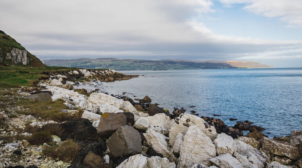 Path Glenarm Coastal Path, south of the village of Glenarm, in Northern Ireland, large white boulders and distant mountains