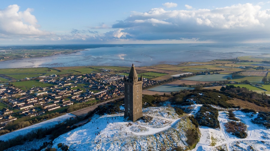 Una torre medieval, un paisaje nevado y un río.