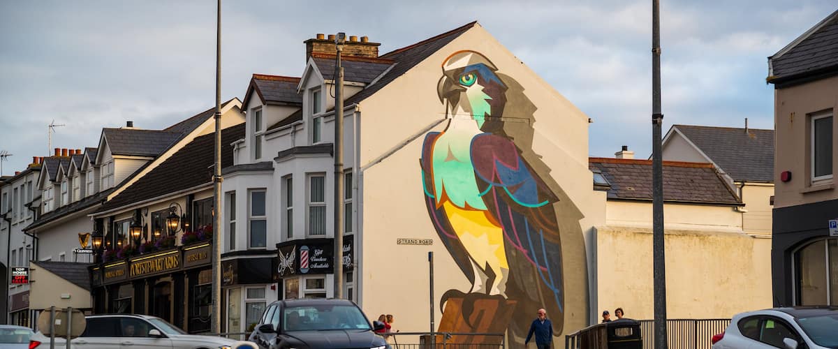 A street with a mural of a parrot on a building.